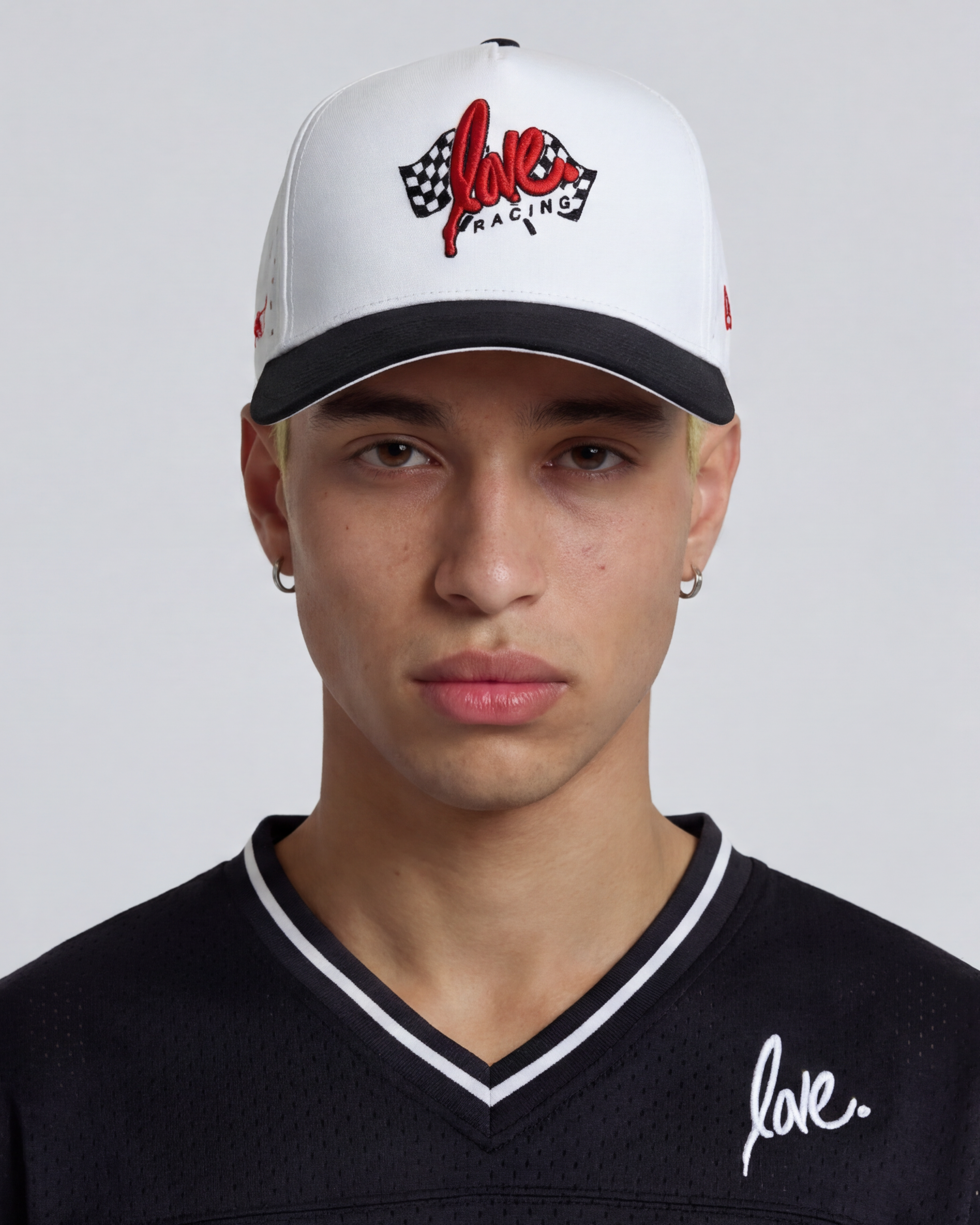 Love Racing hat by Ruben Rojas Person wearing a white cap with red and black design and a black shirt with white text on a gray background