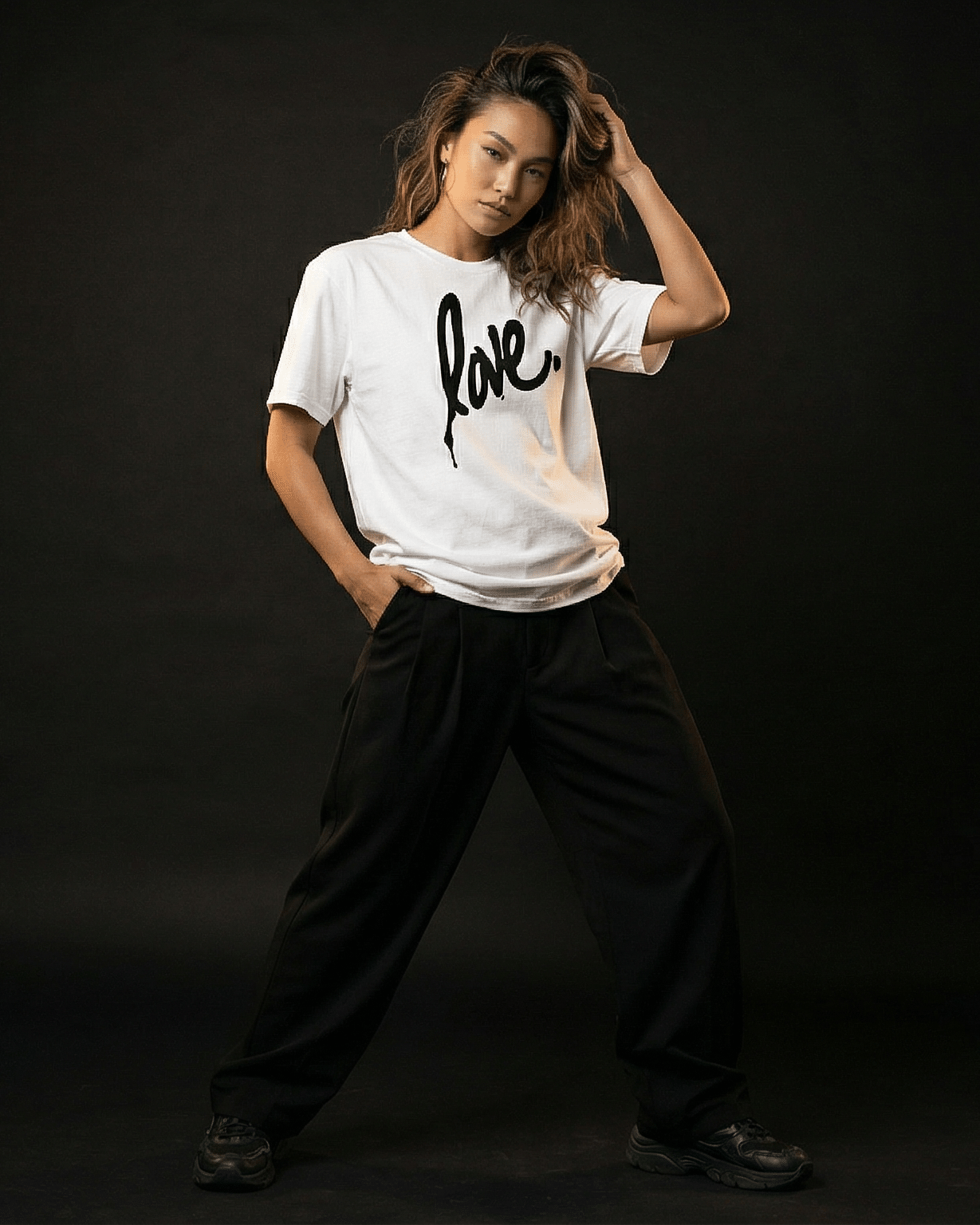 Person wearing a white t-shirt with 'love' printed on it against a black background